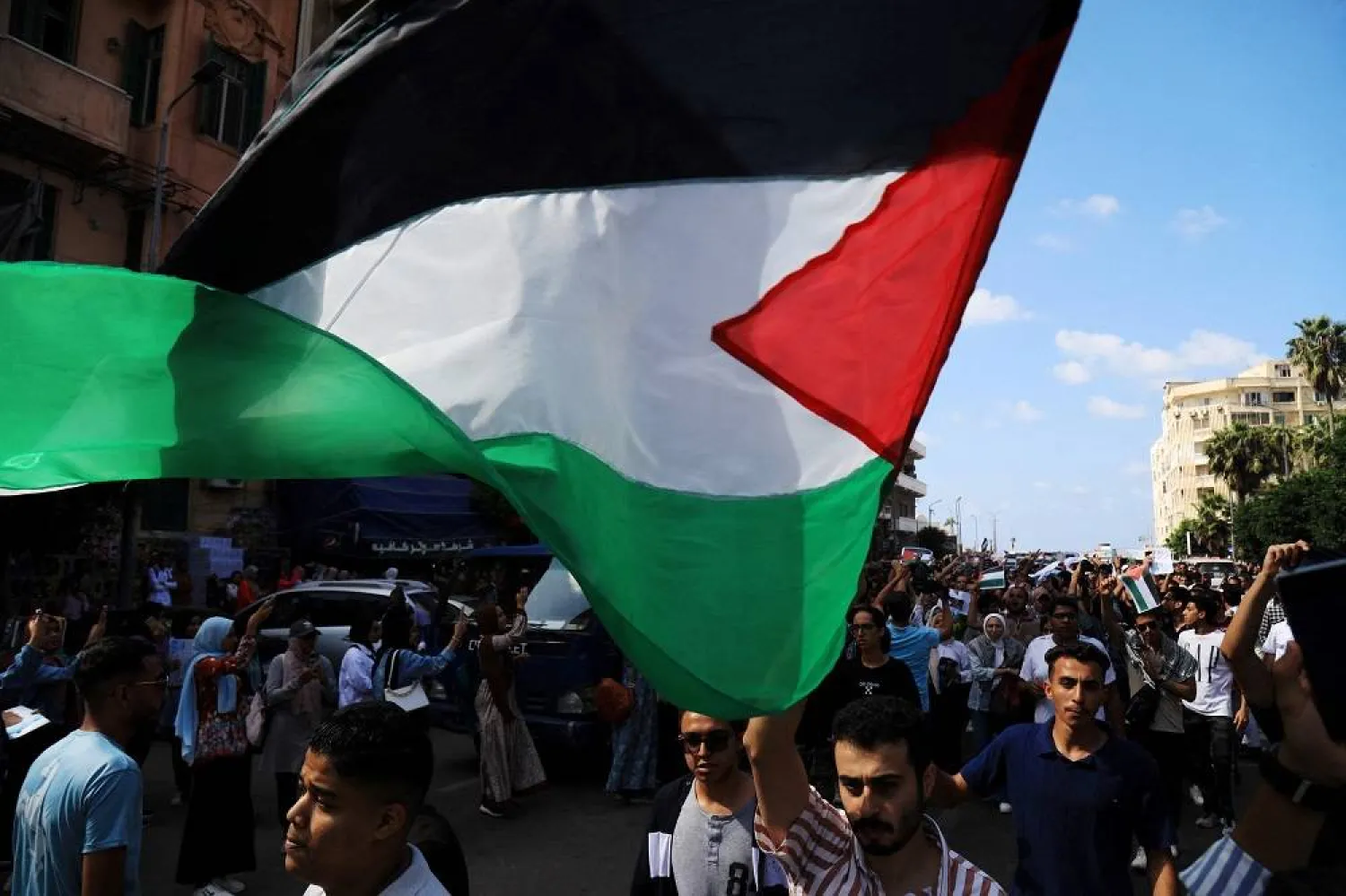 Egyptian students from the Alexandria University hold the Palestinian flag as they take part in a demonstration in northern Mediterranean coastal city of Alexandria on October 18, 2023, denouncing the killing of hundreds of Palestinians following a strike on a hospital in the Gaza Strip. (AFP)