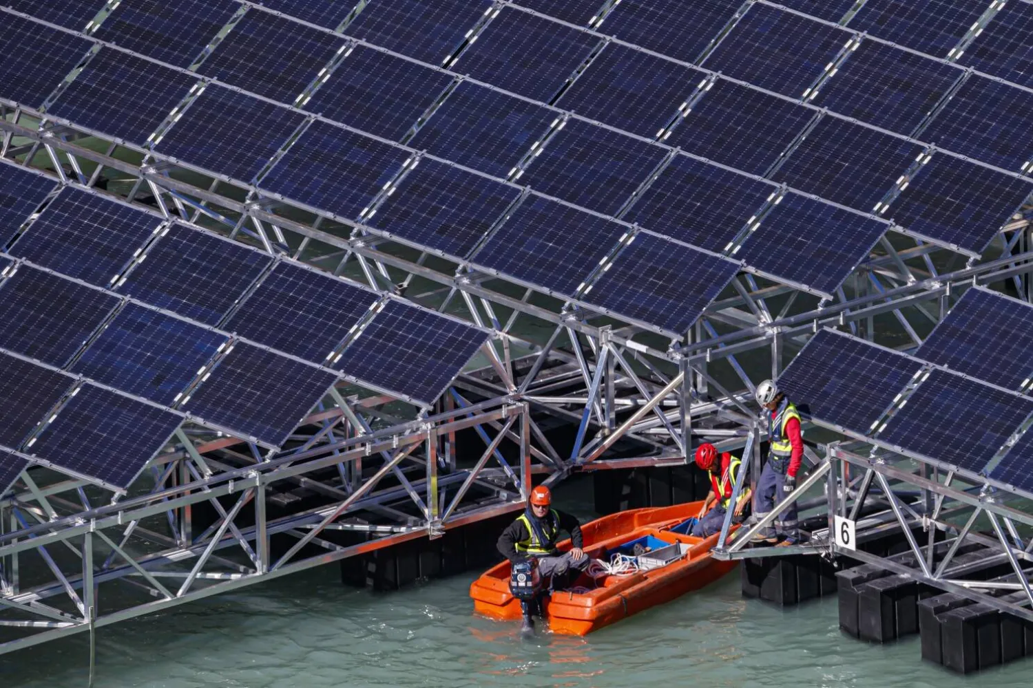 FILE - Workers assemble floating barges with solar panels on the ‘Lac des Toules’, an alpine reservoir lake, in Bourg-Saint-Pierre, Switzerland, Tuesday, Oct. 8, 2019. (Valentin Flauraud/Keystone via AP, File)

