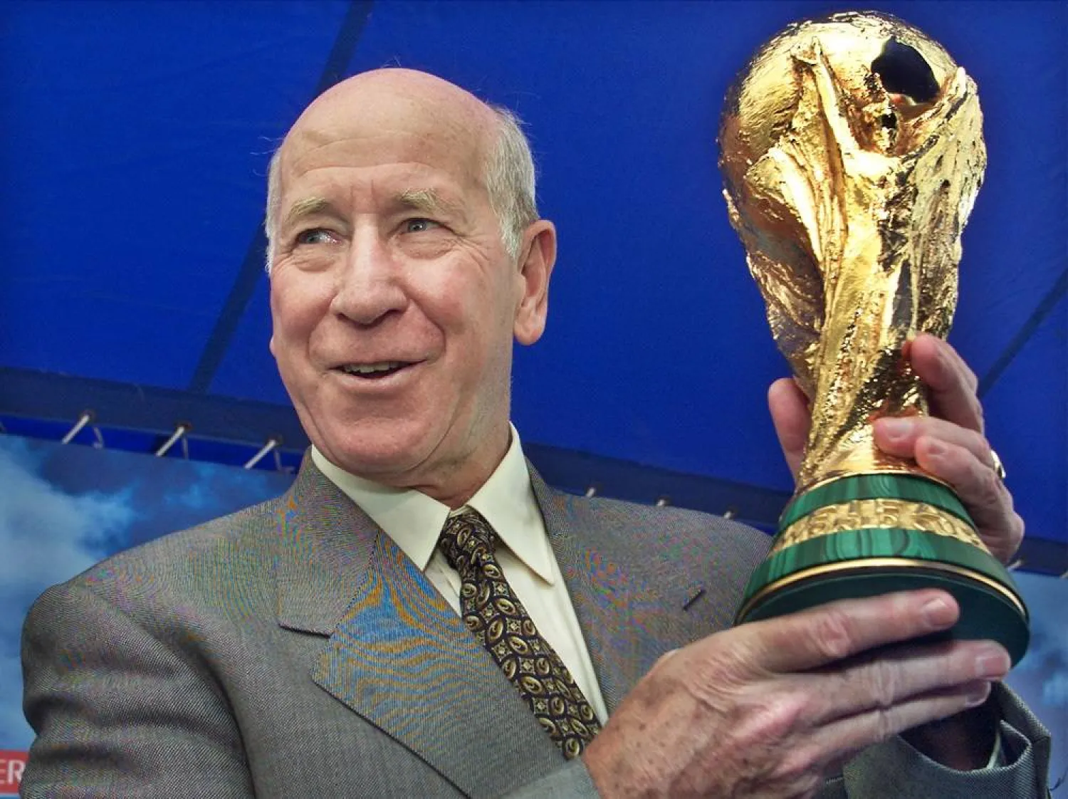 FIFA Ambassador and England soccer legend Bobby Charlton holds up the FIFA World Cup trophy at a kick-off of the trophy's 10-city tour of Japan in Yokohama, venue of the World Cup final match, west of Tokyo March 9, 2002. (Reuters)