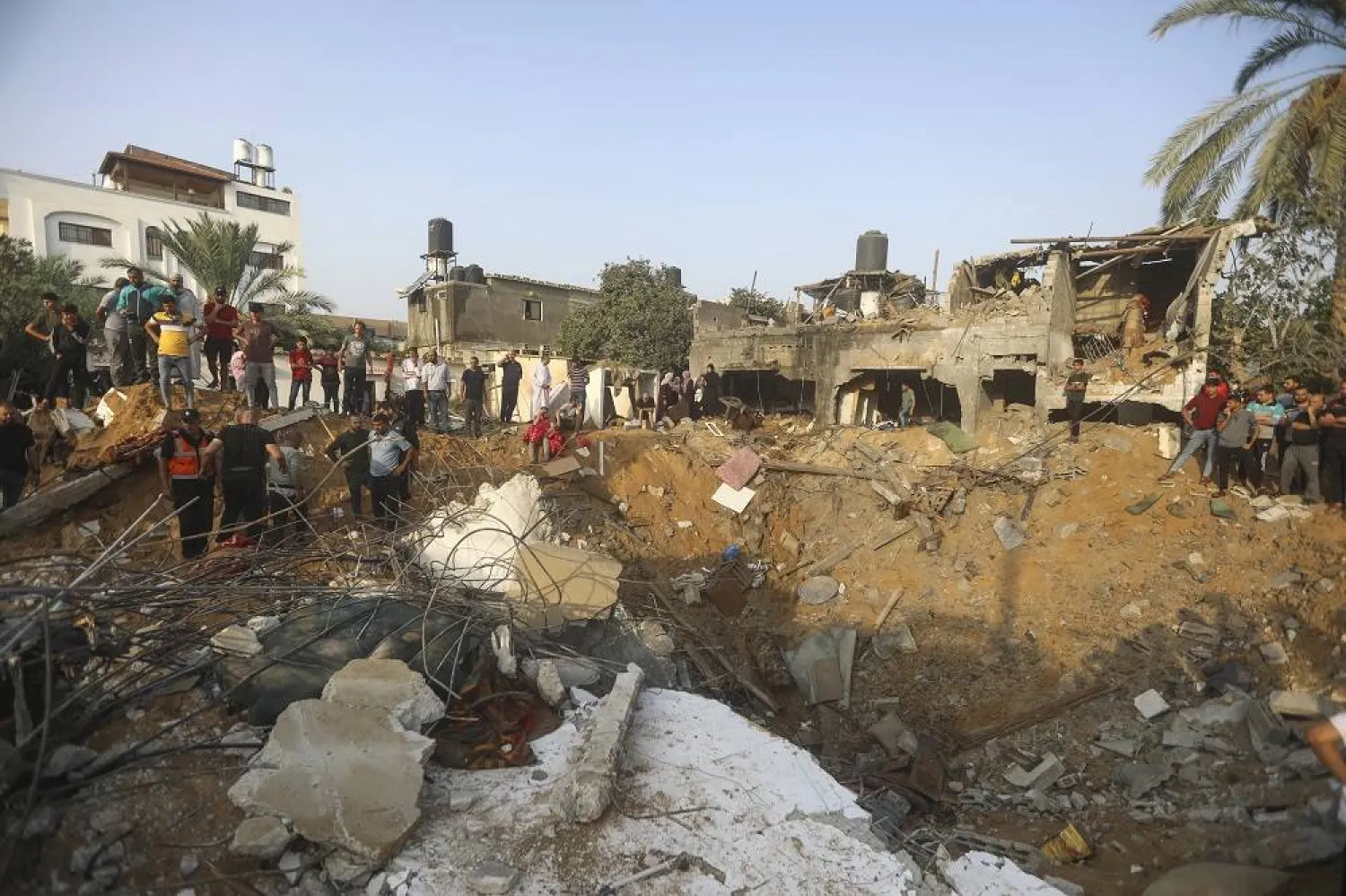 Palestinians inspect the damage of a destroyed house that was hit by an Israeli airstrike in town of Khan Younis, southern Gaza Strip, Tuesday, Oct. 24, 2023. (AP)