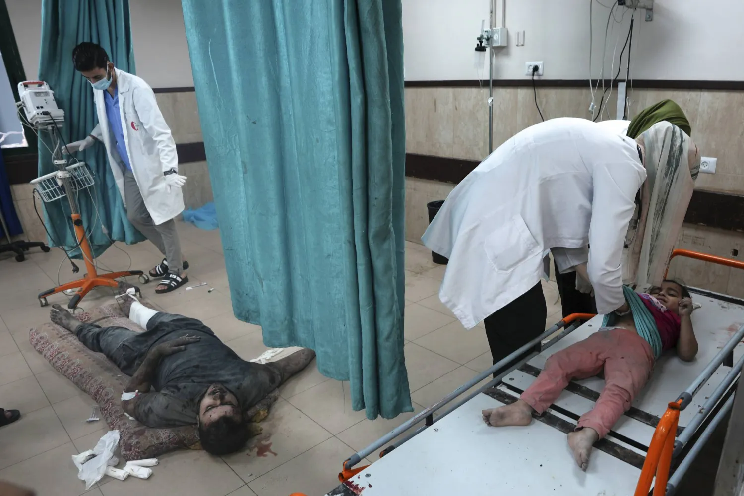مسعفون يساعدون الفلسطينيين المصابين في القصف الإسرائيلي لقطاع غزة في مستشفى بدير البلح (أ.ب)