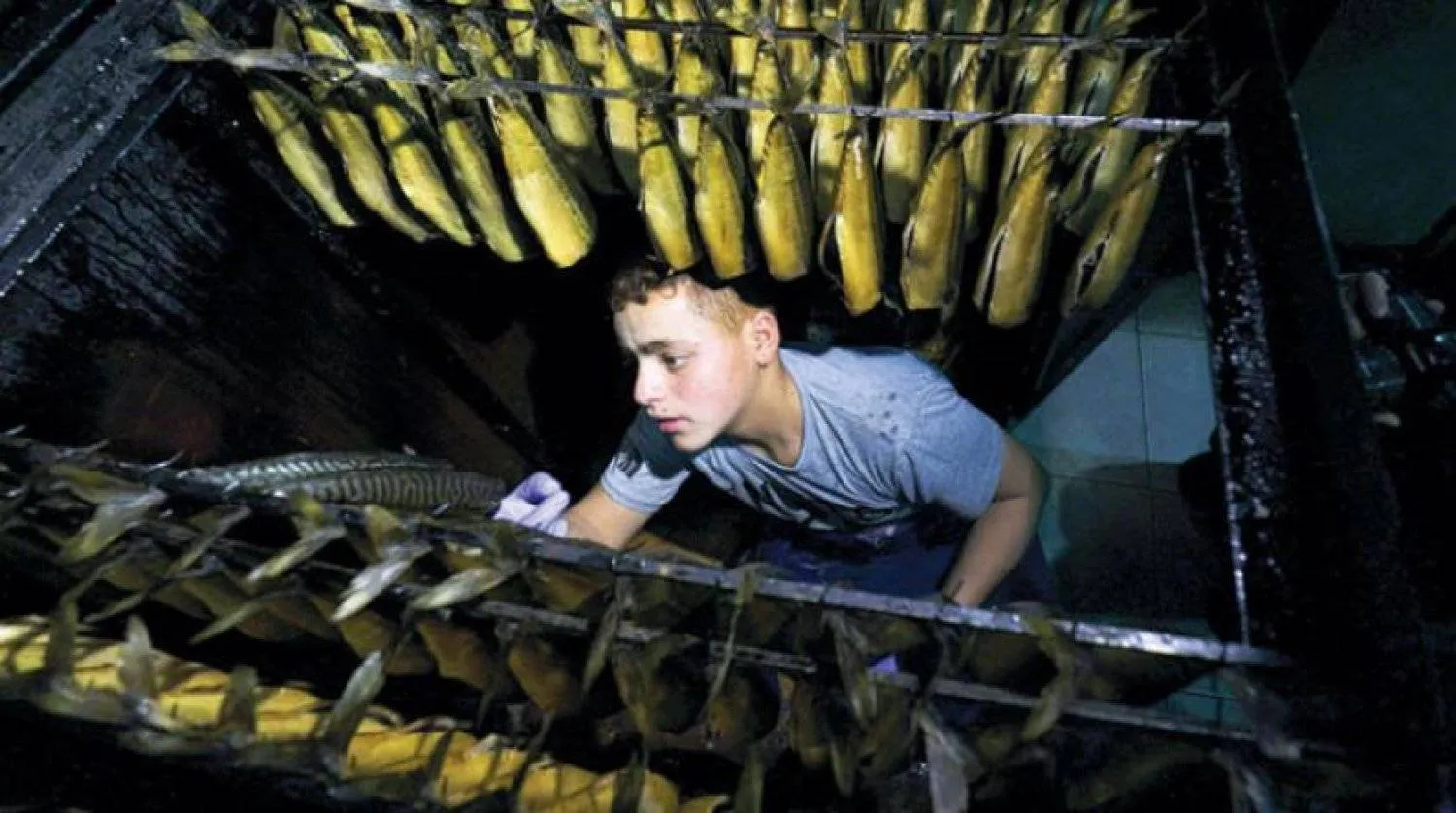 A Palestinian man prepares salted fish to be sold in a market ahead of Eid al-Fitr in Rafah, in the southern Gaza Strip, on April 26, 2022. (AFP)
