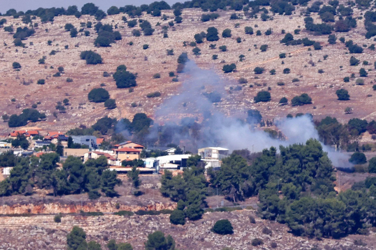 الدخان يتصاعد فوق المباني في قرية مارون الراس بجنوب لبنان (أ.ف.ب)