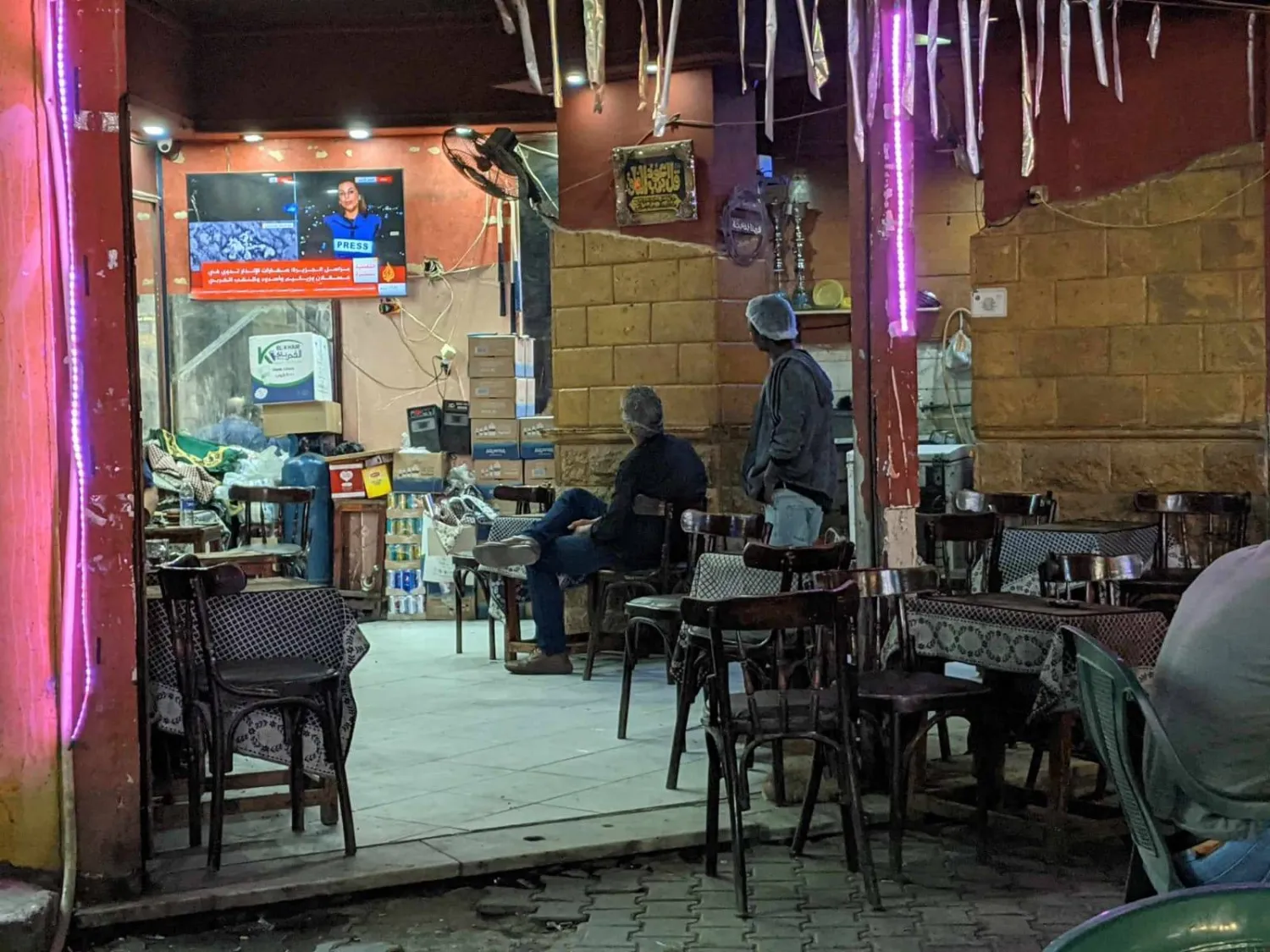 مصريان يتابعان أخبار الحرب في غزة بأحد مقاهي القاهرة، يوم الخميس (الشرق الأوسط)
