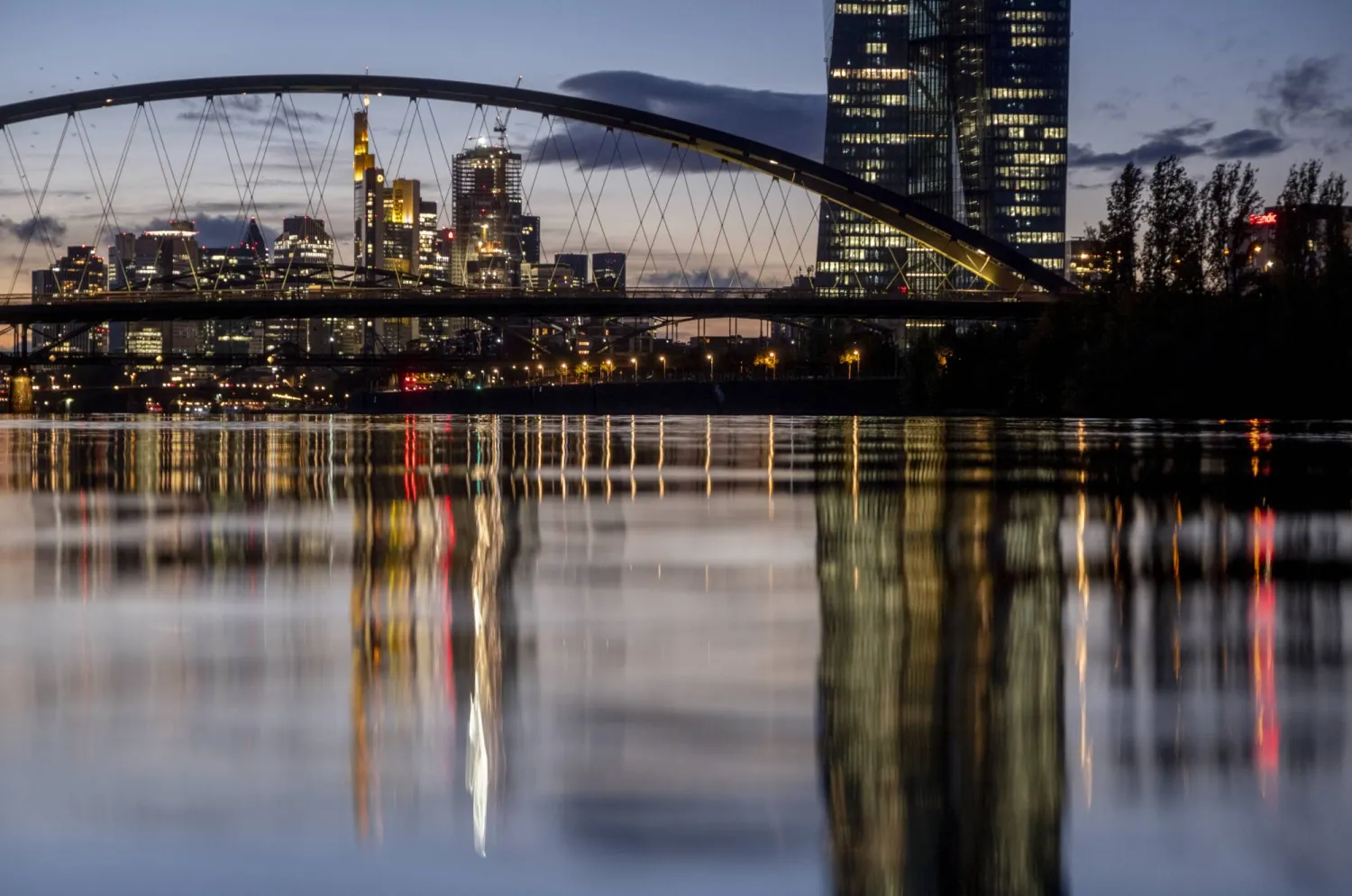 البنك المركزي الأوروبي، على اليمين، ومباني المنطقة المصرفية تنعكس في نهر الماين في فرانكفورت، ألمانيا، الجمعة 27 أكتوبر (تشرين الاول) 2023 (أ ف ب)