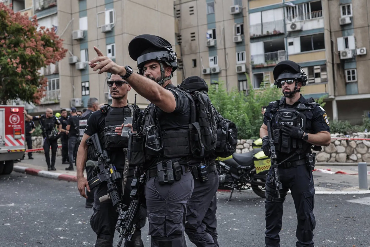 أفراد من «جهاز الأمن الإسرائيلي» يقومون بتأمين المنطقة التي يقع فيها مبنى سكني أُصيب بصاروخ أُطلق من غزة (د.ب.أ)