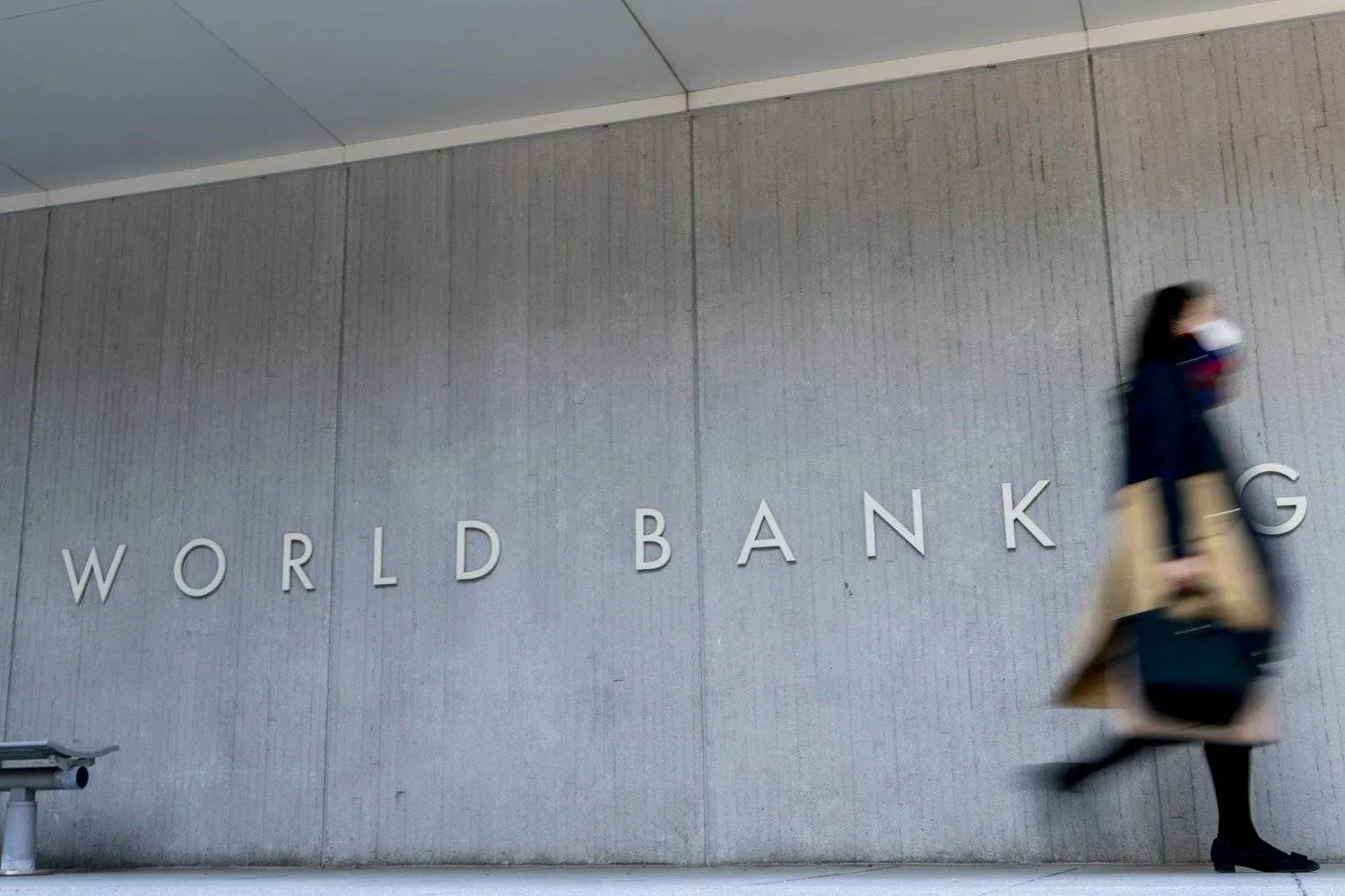A woman walks in front of the World Bank headquarters in Washington, DC. (AP) 