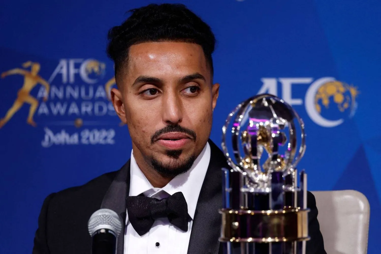 سالم الدوسري حاملاً جائزة أفضل لاعب في آسيا (أ.ف.ب)