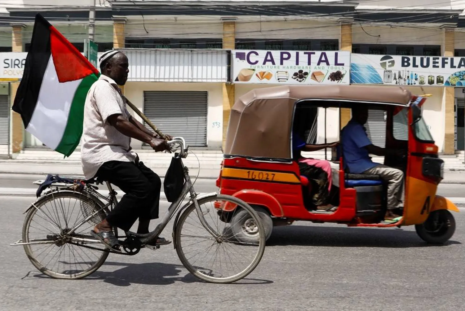  A cyclist holds a Palestinian flag to express support for Palestinians, as he rides along a street in Mogadishu, Somalia October 12, 2023. (Reuters)