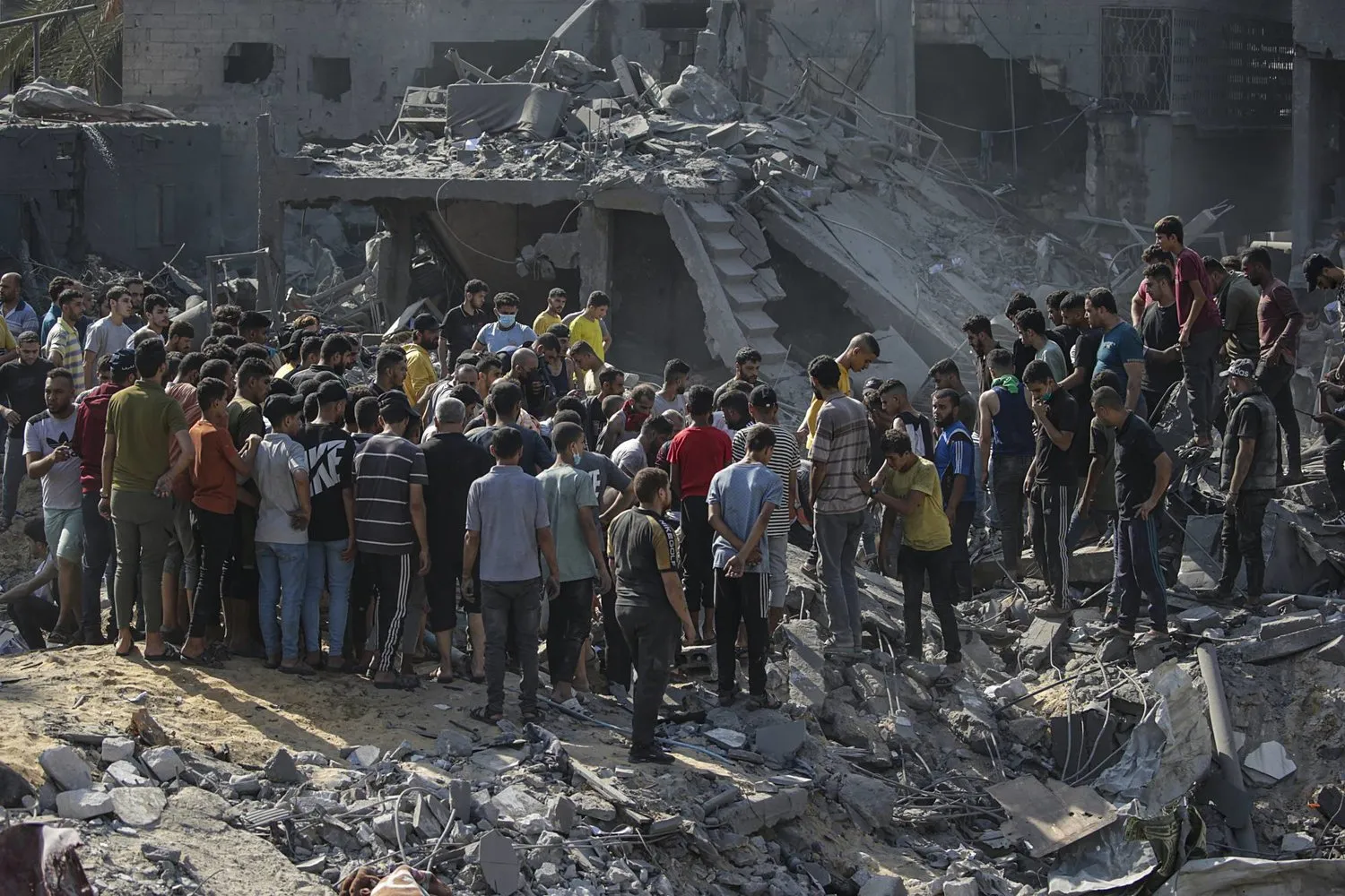 İsrail saldırıları sonucu yerle bir olan Cibaliye Mülteci Kampı’ndaki enkazlar arasında hayatta kalanları ve kurbanları arayan Filistinliler. (EPA)