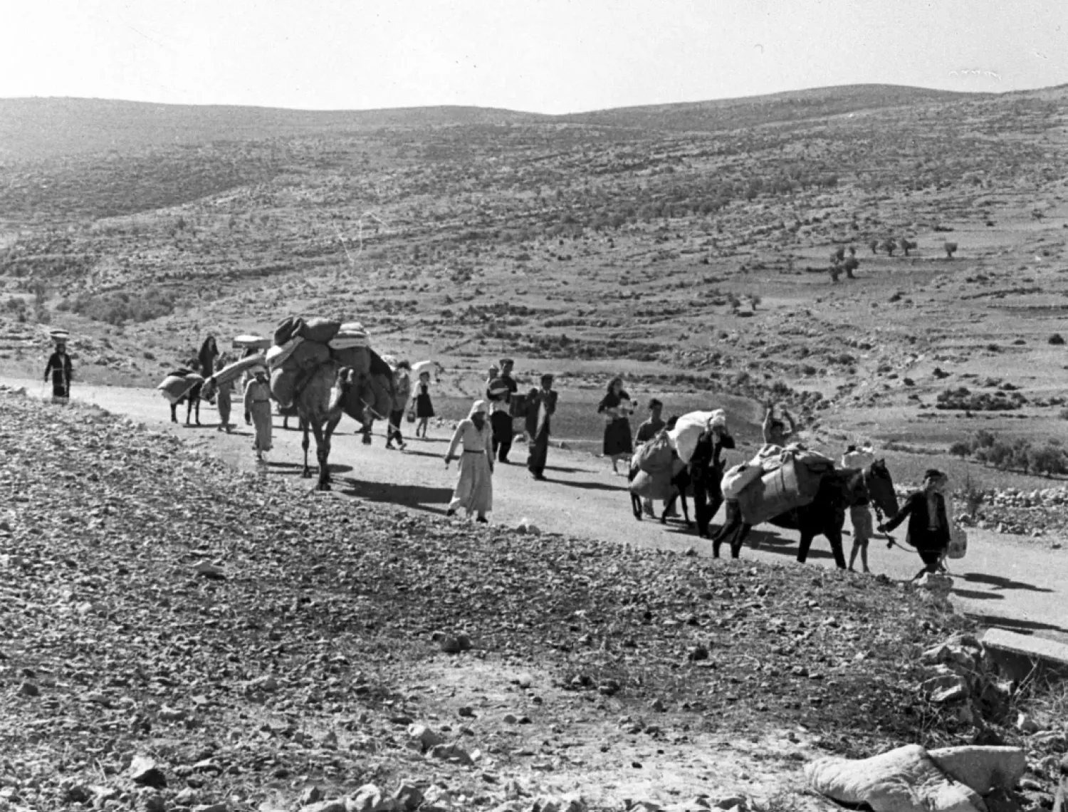  A group of Arab refugees walks along a road from Jerusalem to Lebanon, carrying their children and belongings with them on Nov. 9, 1948. The group was driven from their homes by attacks in Galilee. (AP Photo/Jim Pringle, File)
