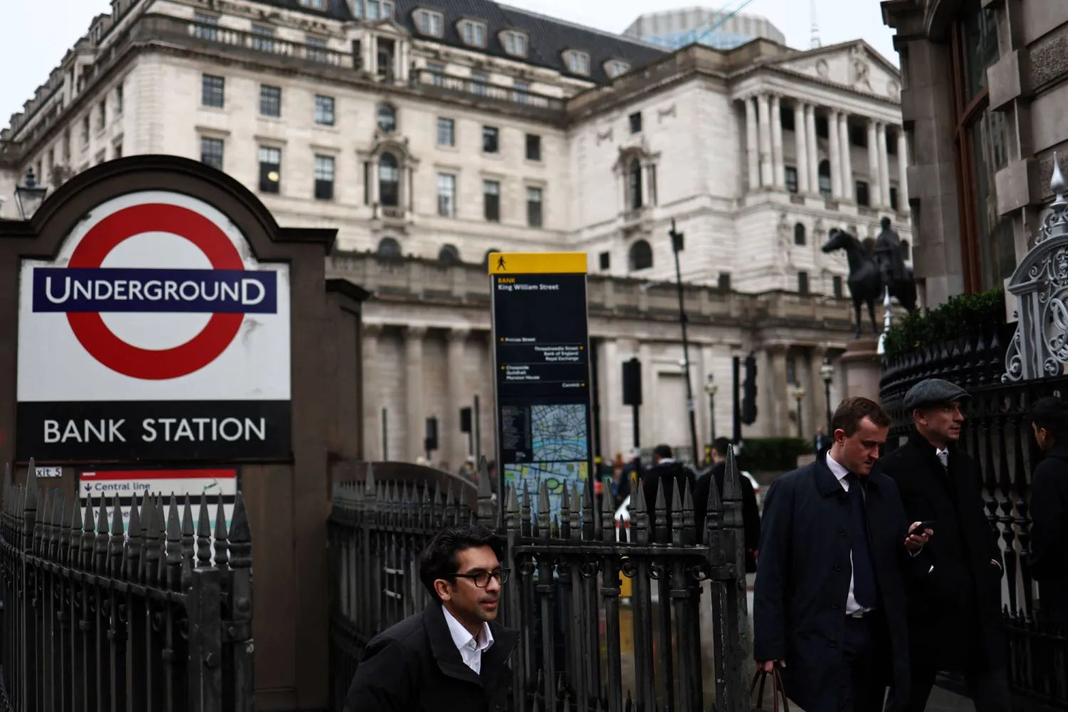 رجل يقف إلى جانب مبنى «بنك إنجلترا» وسط لندن (أ.ف.ب)