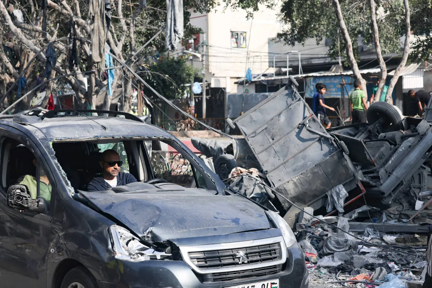 رجل يقود سيارة مدمرة في شارع دمره القصف الإسرائيلي في رفح بجنوب قطاع غزة (أ.ف.ب)