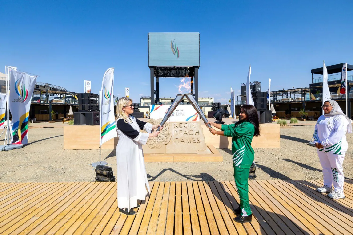 جان بيترسون رئيسة قطاع الرياضة في نيوم خلال تسلمها شعلة الدورة (الشرق الأوسط)