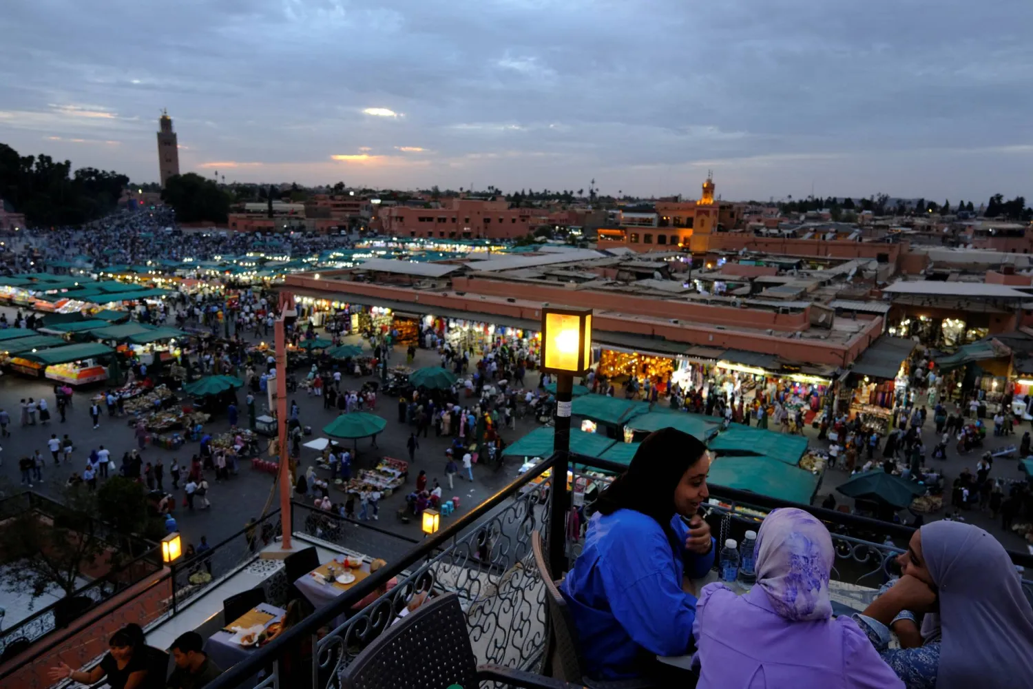 مواطنون وسائحون متجمعون بميدان جامع الفنا في مدينة مراكش المغربية (رويترز)