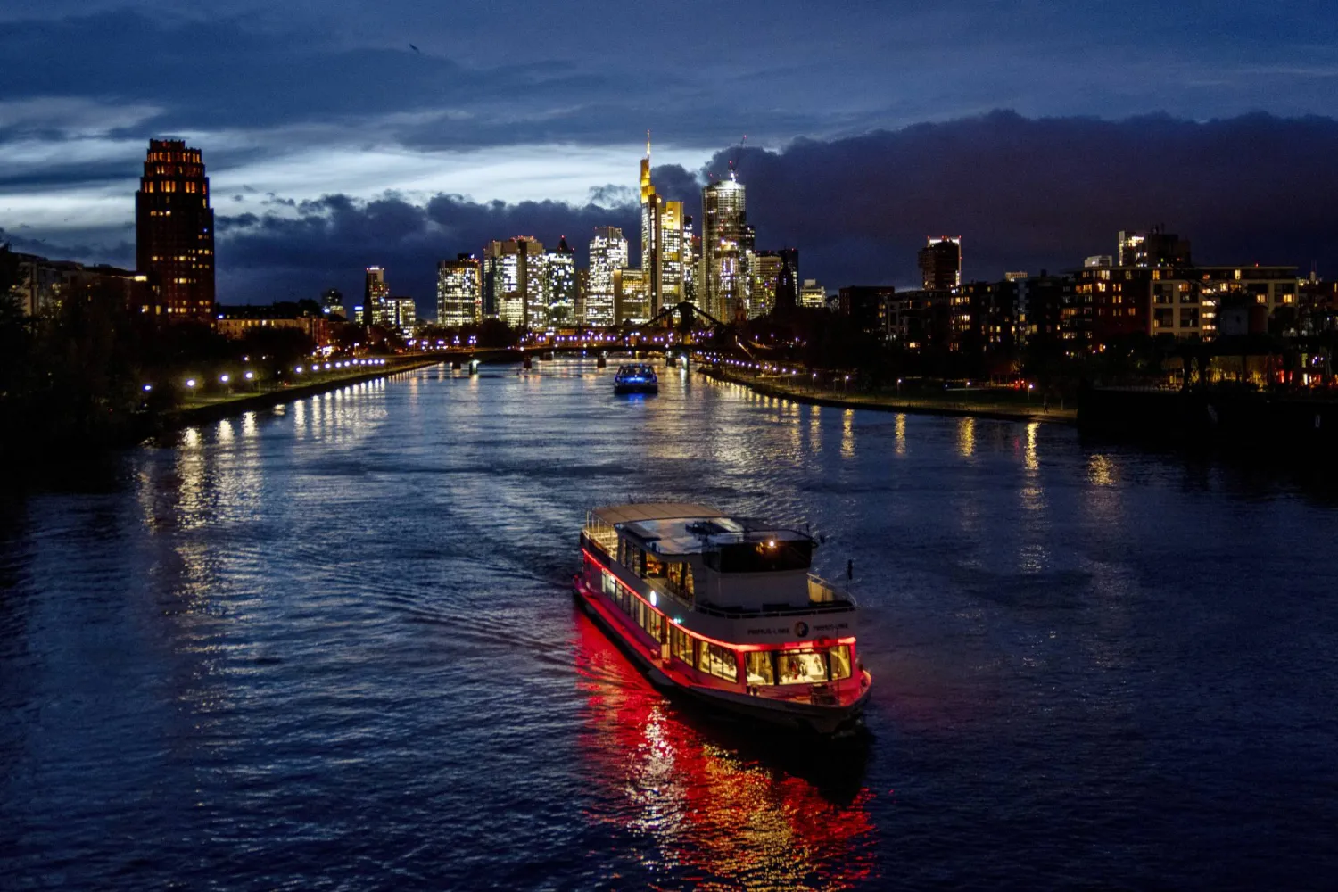 مركب رحلات تمر في نهر ماين قرب الضاحية المالية وسط مدينة فرانكفورت الألمانية (أ.ب)