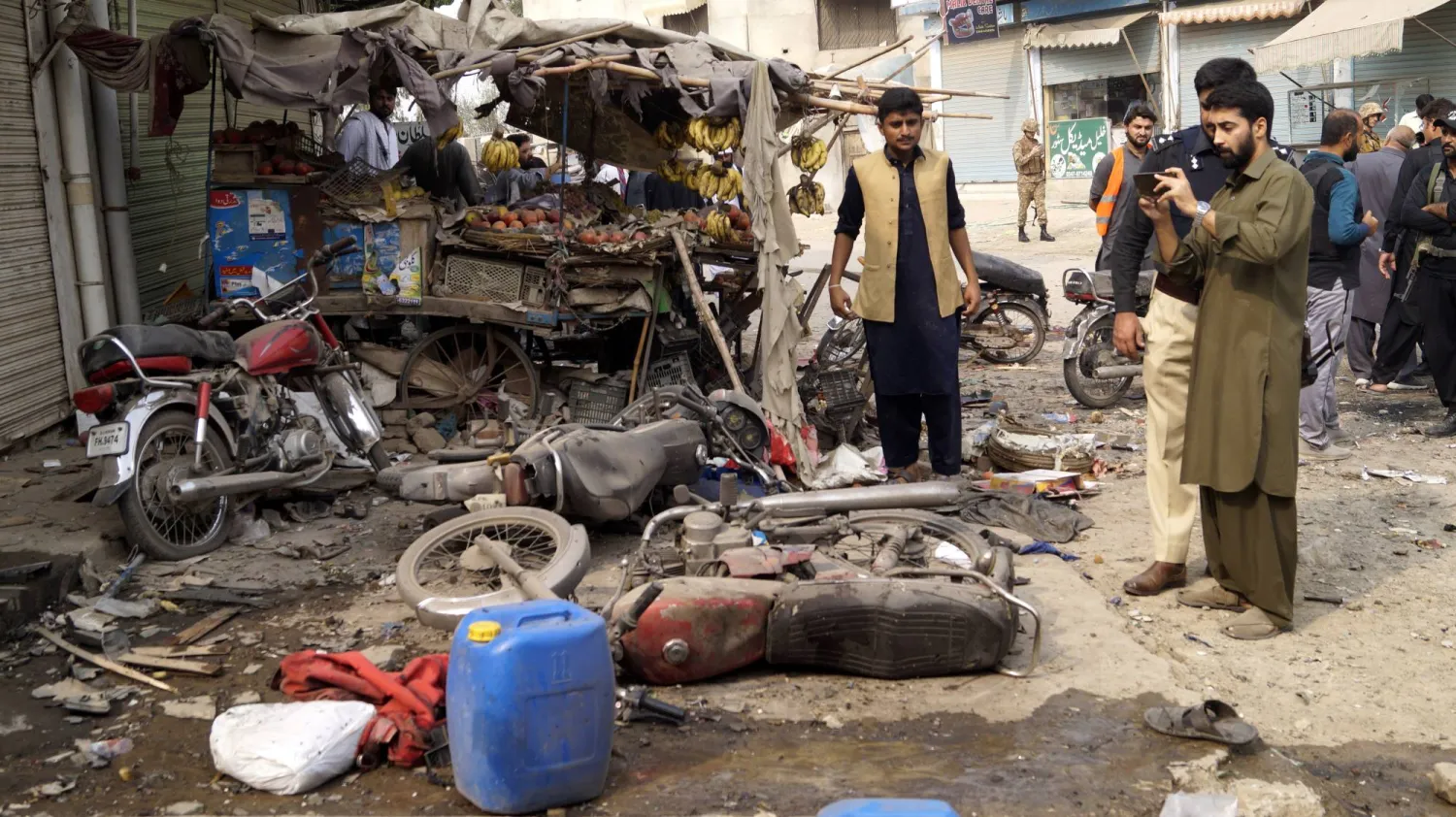 أمنيون باكستانيون يتفقدون مكان انفجار قنبلة استهدف الشرطة في ديرا إسماعيل خان (باكستان ) (إ.ب.أ)