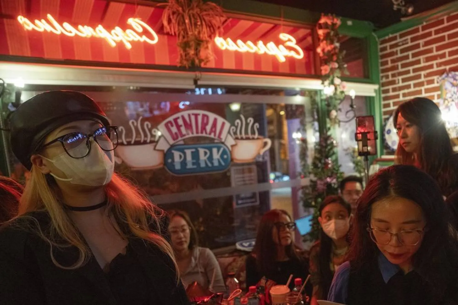 Fans of the hit sit-com "Friends" gather at a cafe that pays homage to the Central Perk cafe in the series to commemorate the death of Matthew Perry who played the Chandler Bing character, in Shanghai, Wednesday, Nov. 1, 2023. (AP)