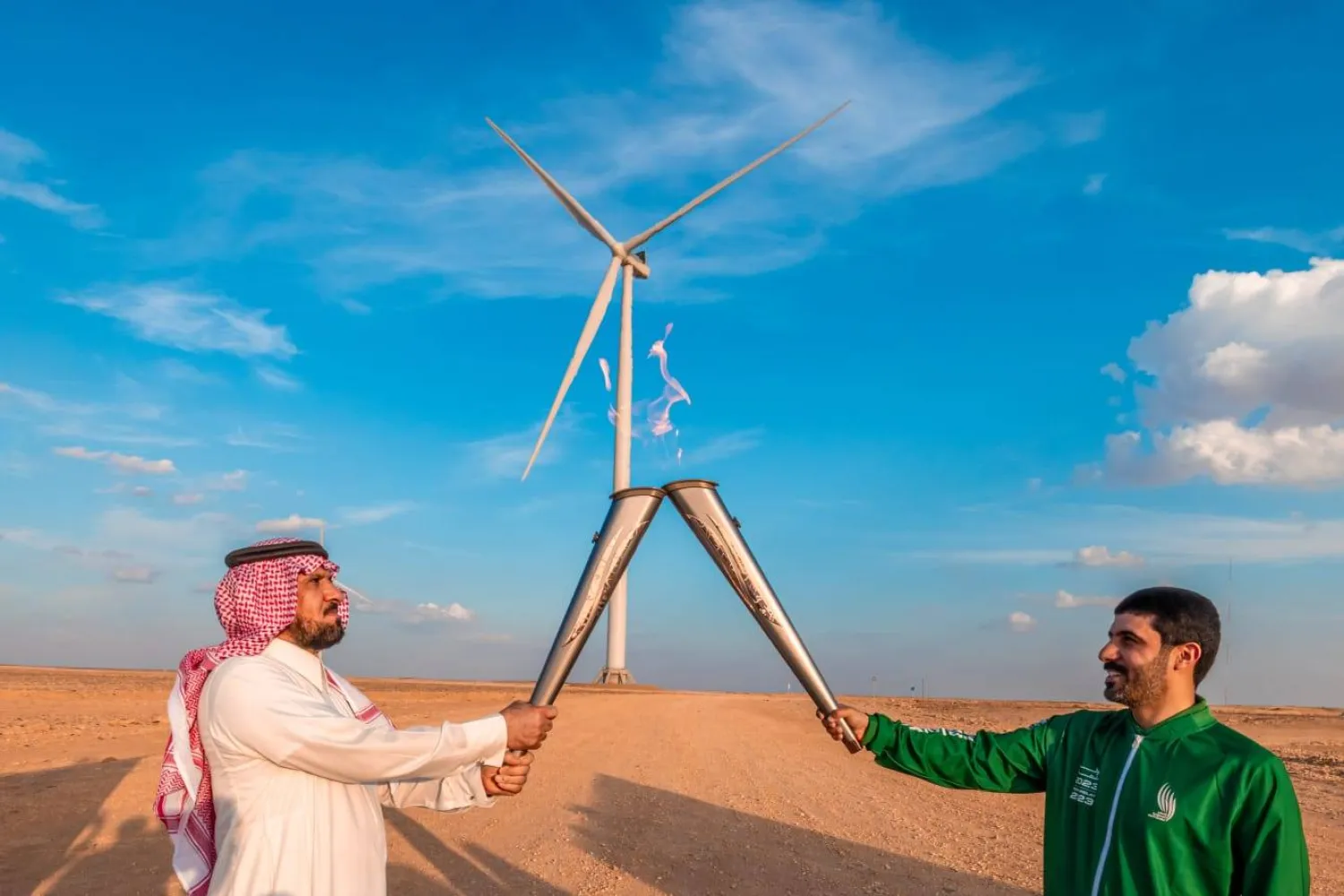 عبد المجيد الرويلي ووكيل إمارة المنطقة حسين آل سلطان يحملان الشعلة من أمام مشروع الطاقة المتجددة (الشرق الأوسط)