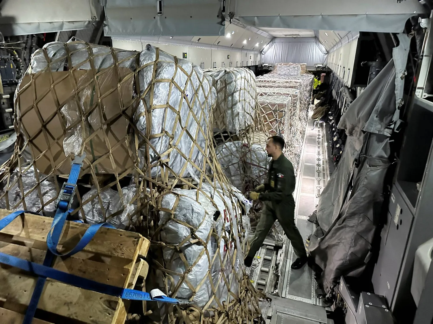 تحميل المساعدات الإنسانية التي سيتم تسليمها لغزة على متن طائرة عسكرية تابعة لسلاح الجو الفرنسي (رويترز)