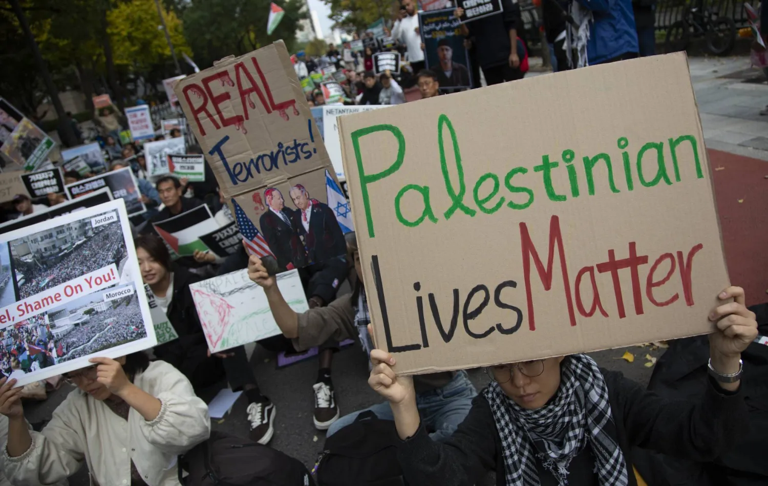 فلسطينيون وعرب يعيشون في كوريا الجنوبية مع أعضاء المجموعات المدنية يحضرون مسيرة تضامنية مع فلسطين ويرفعون لافتة «حياة الفلسطينيين مهمة» بالقرب من سفارة إسرائيل في سيول (إ.ب.أ)