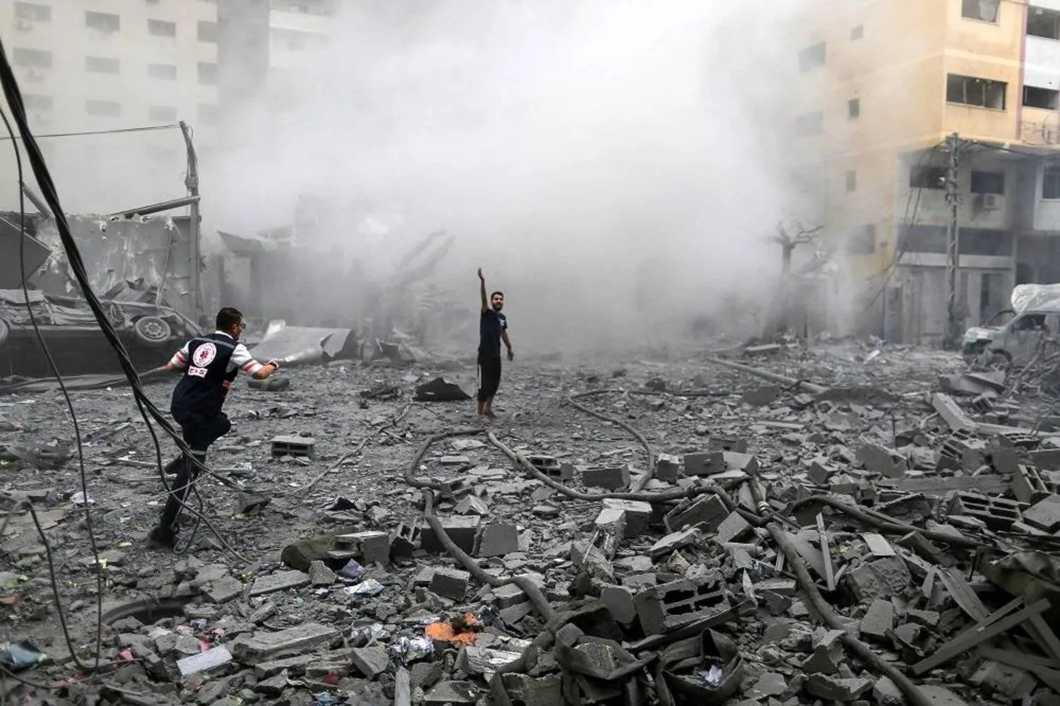 Palestinians stand among rubble following Israeli strikes on a residential building, in Gaza City, October 9, 2023. (Reuters)
