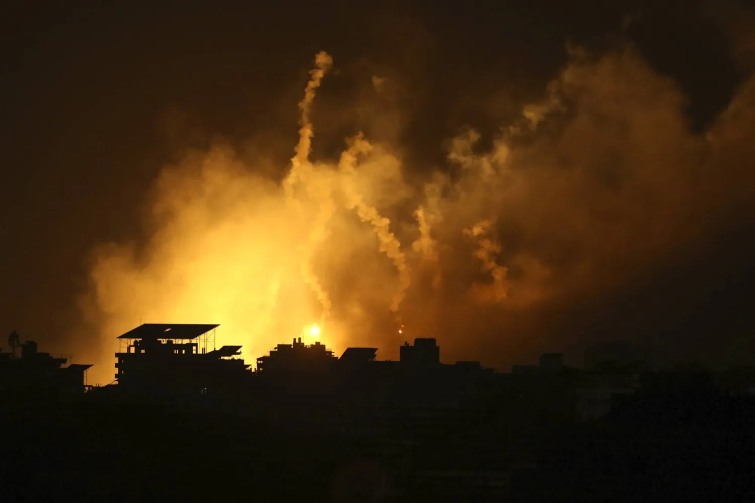 تصاعد النيران والدخان من المباني بعد غارات جوية إسرائيلية على غزة (أ.ب)