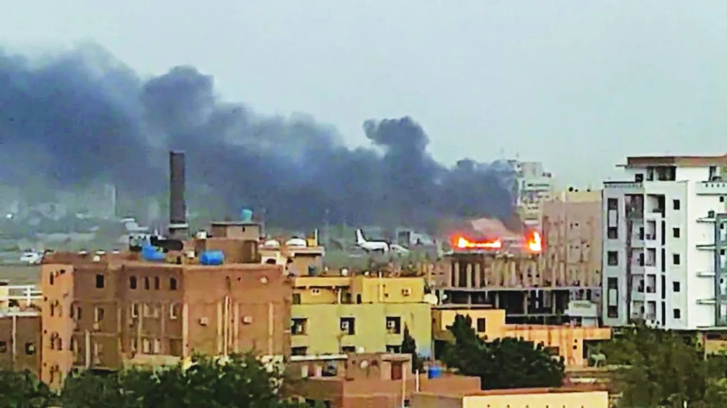 أعمدة الدخان الكثيف تتصاعد من جهة مطار الخرطوم الدولي الملاصق لمقر القيادة العامة للجيش (أرشيفية - رويترز)