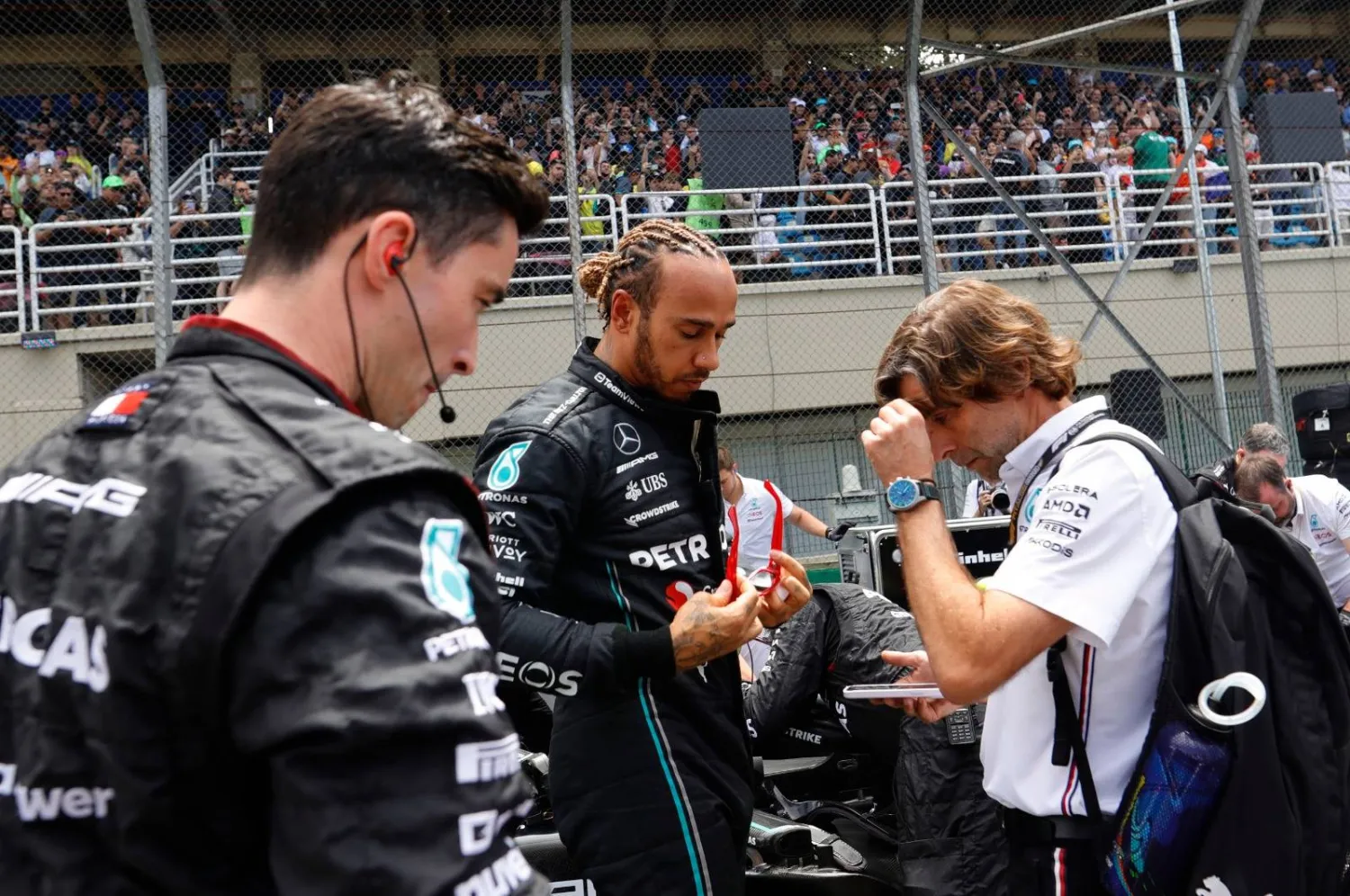 هاميلتون في حديث مع أعضاء فريقه خلال منافسات جائزة البرازيل الكبرى (أ.ب)