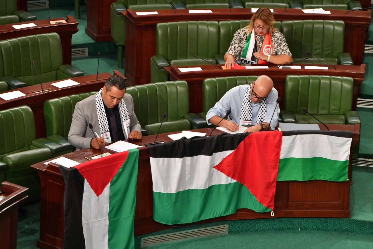 نواب في البرلمان التونسي يضعون الأعلام الفلسطينية تضامناً مع ضحايا غزة (أ.ف.ب)