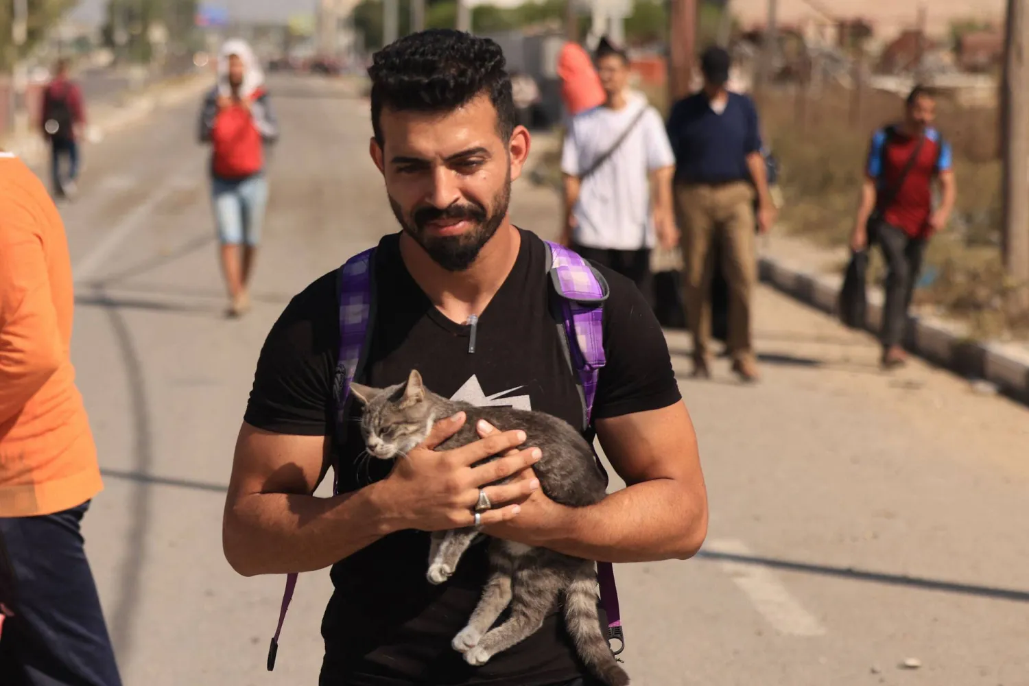 فلسطيني ييسير وقطته معه نحو جنوب قطاع غزة (أ.ف.ب)