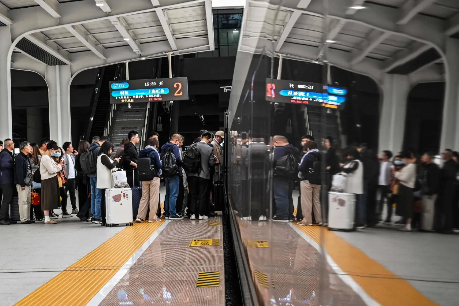 مواطنون صينيون في إحدى محطات القطار السريع بمدينة جيانغين شرق البلاد (أ.ف.ب)