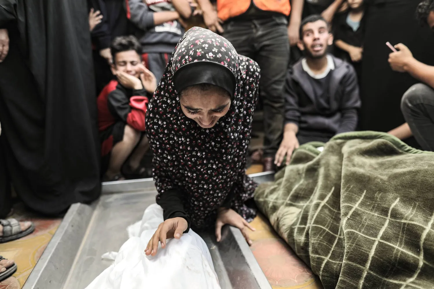 سيدة فلسطينية تبكي على أقارب قُتلوا وسط الحرب في مستشفى ناصر في خان يونس (إ.ب.أ)