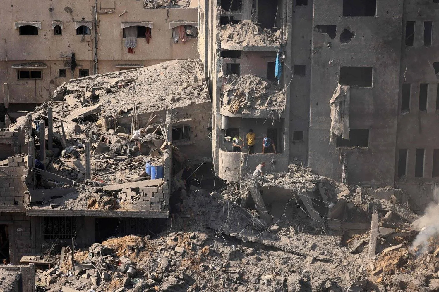 People check buildings destroyed in an Israeli strike on the Bureij refugee camp in the central Gaza Strip on November 2, 2023, as battles between Israel and the Palestinian Hamas movement continue. (Photo by MAHMUD HAMS / AFP)
