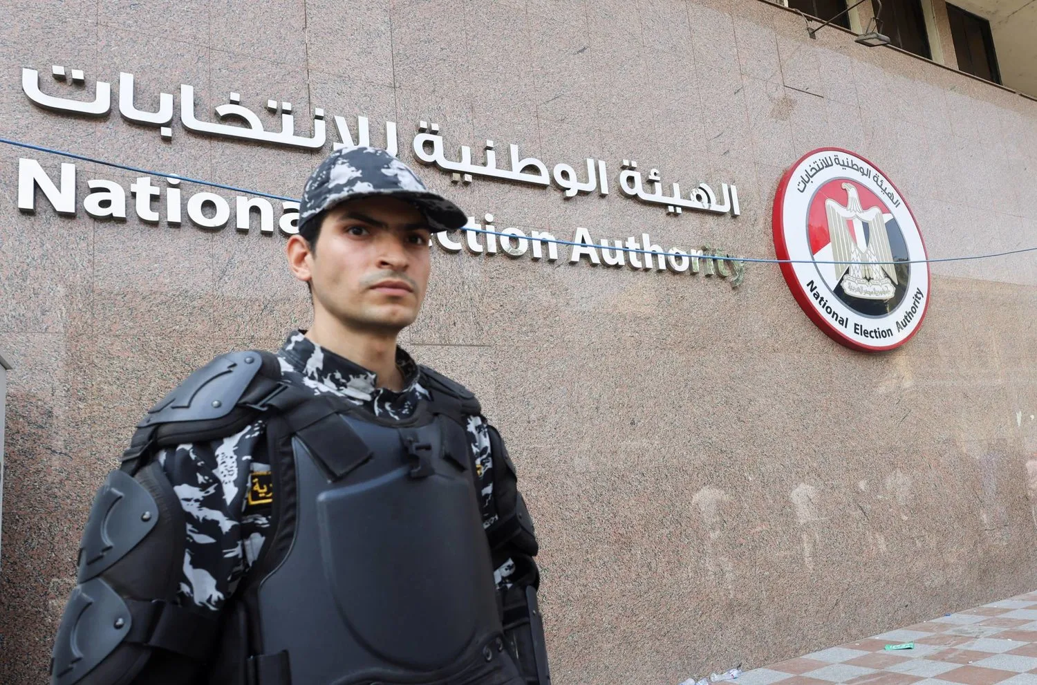 Mısırlı bir çevik kuvvet polisi, bir aday 9 Ekim 2023'te Mısır'ın Kahire kentinde Aralık 2023'te yapılması planlanan başkanlık seçimleri için adaylık belgelerini sunarken Ulusal Seçim Kurumu önünde nöbet tuttu ( Reuters)