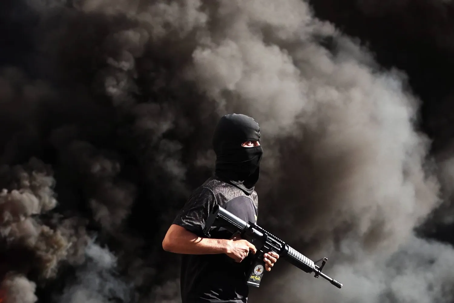 مسلح فلسطيني خلال اقتحام القوات الإسرائيلية مخيم جنين في الضفة الغربية (إ.ب.أ)