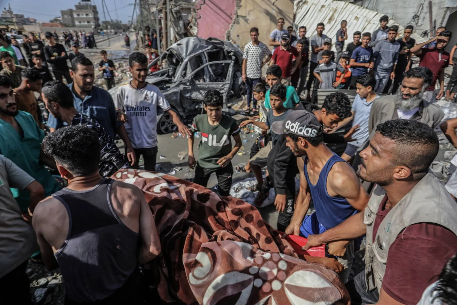 فلسطينيون يحملون جثة شخص قتلته غارة جوية إسرائيلية على رفح في جنوب قطاع غزة (د.ب.أ)