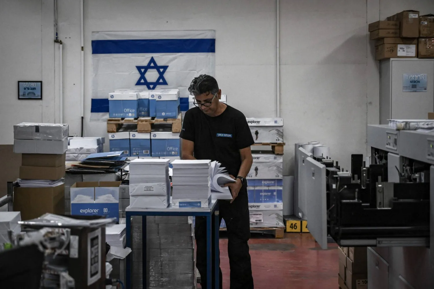 رجل يعمل داخل مصنع طباعة في كيبوتس بيري في جنوب إسرائيل (أ.ف.ب)