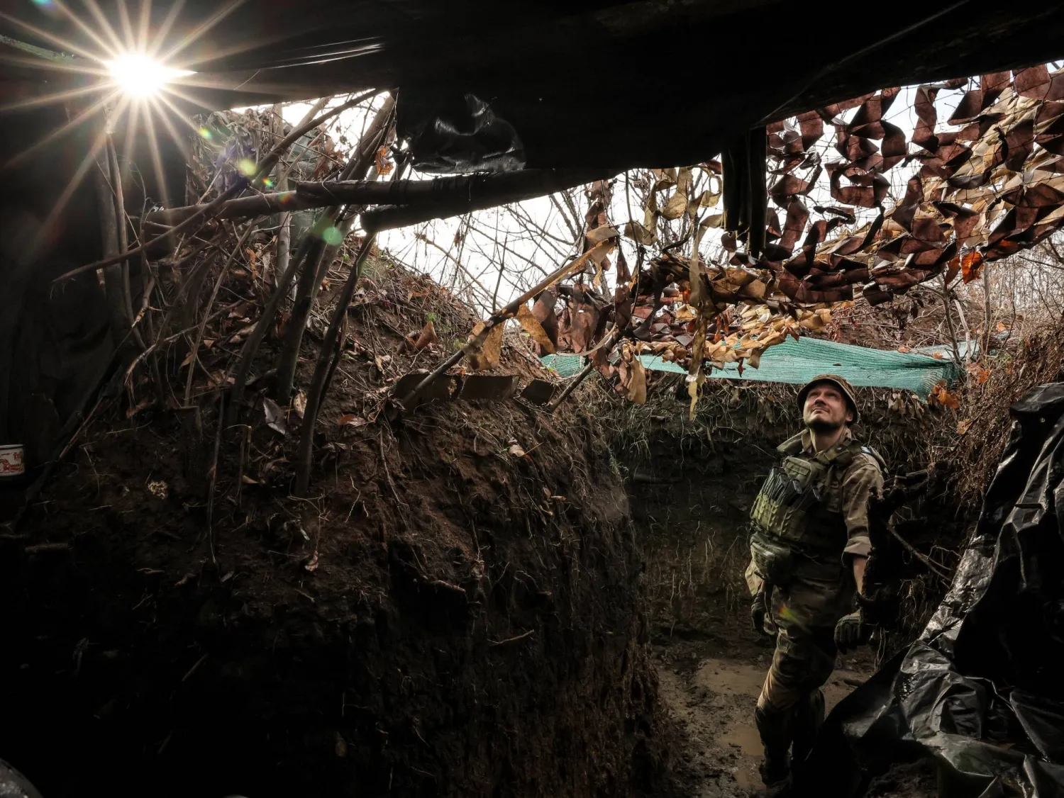 جندي أوكراني يتحرك عبر خندق في منطقة دونيتسك (إ.ب.أ)