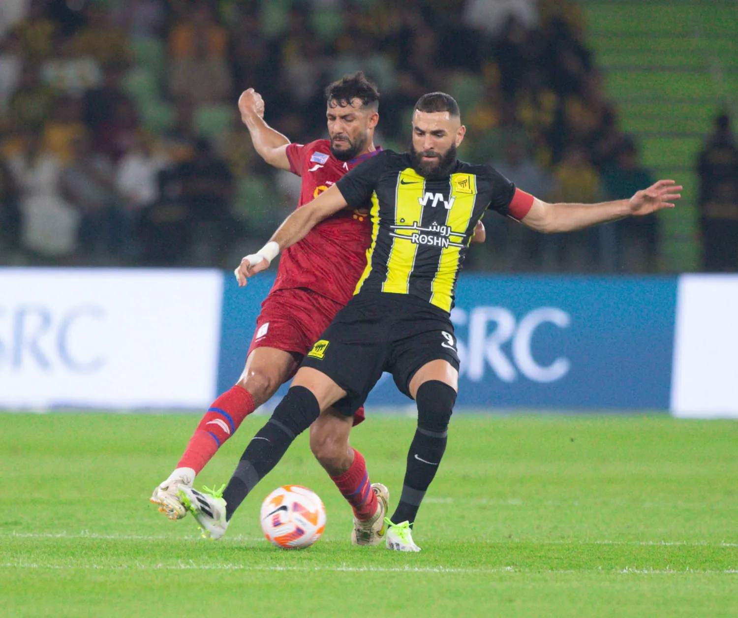 سعد ناطق مدافع أبها يحاول افتكاك الكرة من بنزيمة مهاجم الاتحاد في مباراة الفريقين الجمعة (نادي أبها)
