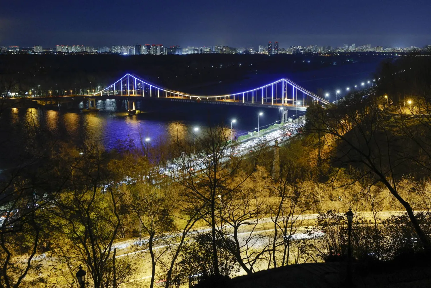 The Parkovyi footbridge spanning over Dnieper river is illuminated in the evening in Kyiv, Ukraine, 10 November 2023, amid the Russian invasion.  EPA/SERGEY DOLZHENKO