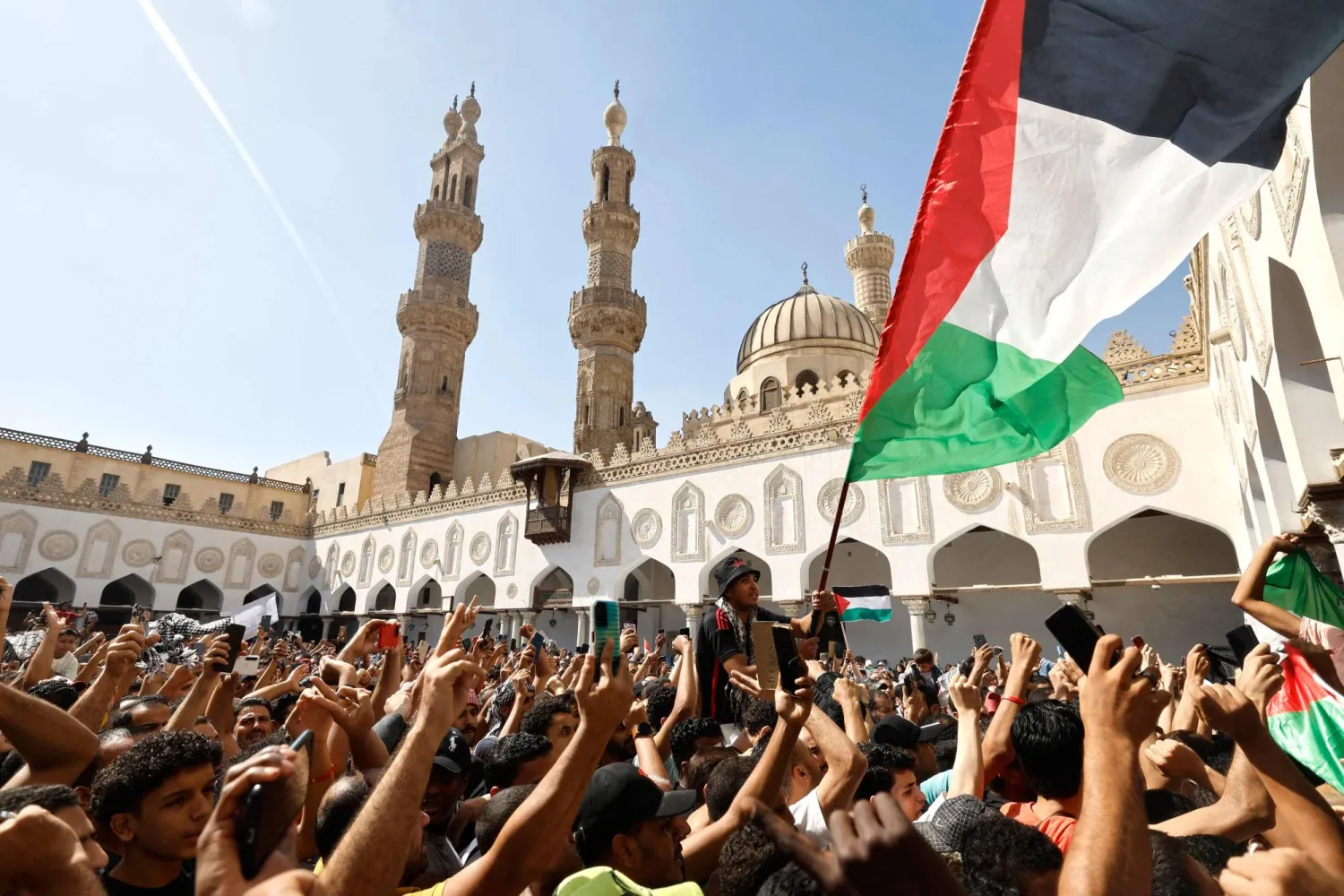 مصلون بالجامع الأزهر يلوحون بالعلم الفلسطيني خلال احتجاجات ضد العدوان الإسرائيلي (أ.ف.ب)