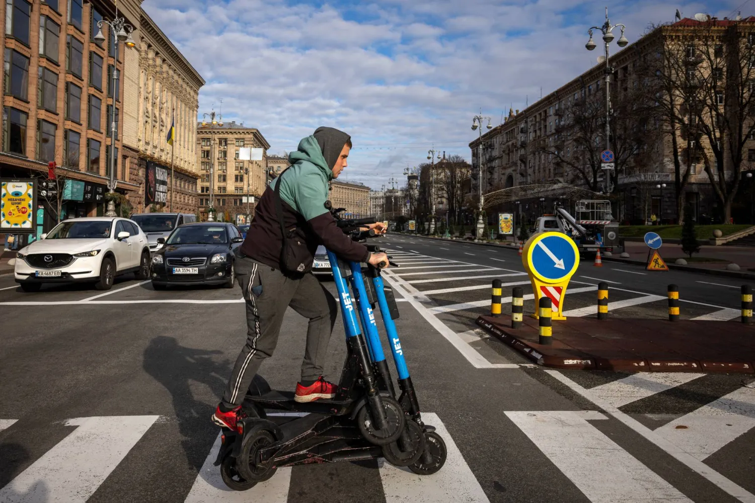 عامل ينقل دراجات نارية كهربائية مستأجرة عبر شارع وسط كييف الاثنين وسط الهجوم الروسي على أوكرانيا (رويترز)