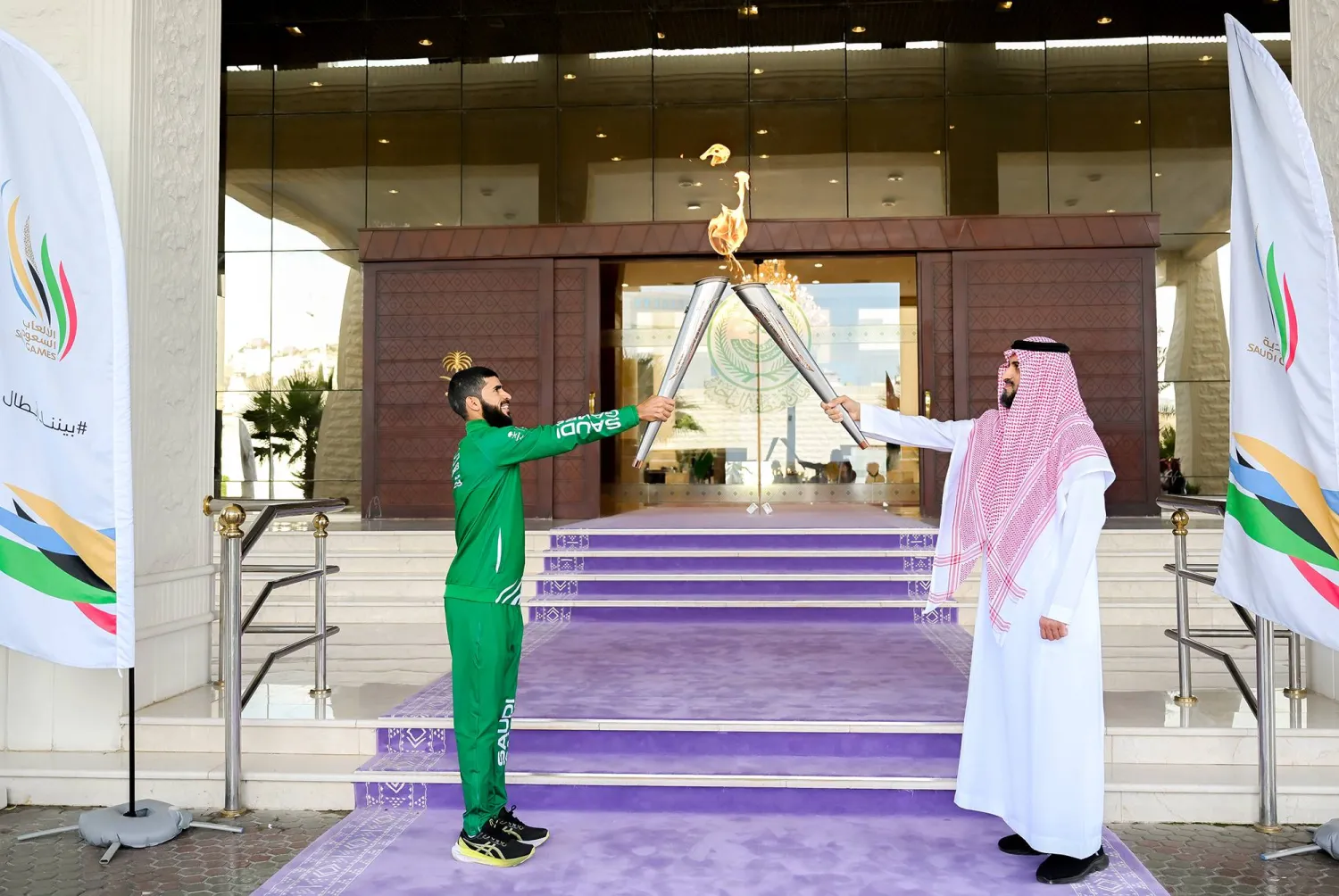 عبد المنعم الشهري وكيل إمارة الباحة يتسلم شعلة دورة الألعاب السعودية من اللاعب عبد الرحمن الغامدي (الشرق الأوسط) 