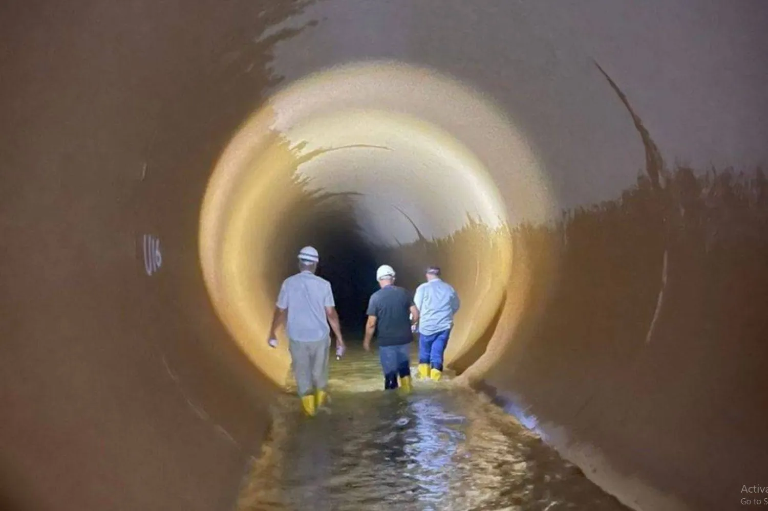 فنيون داخل أنبوب النهر الصناعي في أثناء عملية صيانة سابقة (إدارة النهر الصناعي)