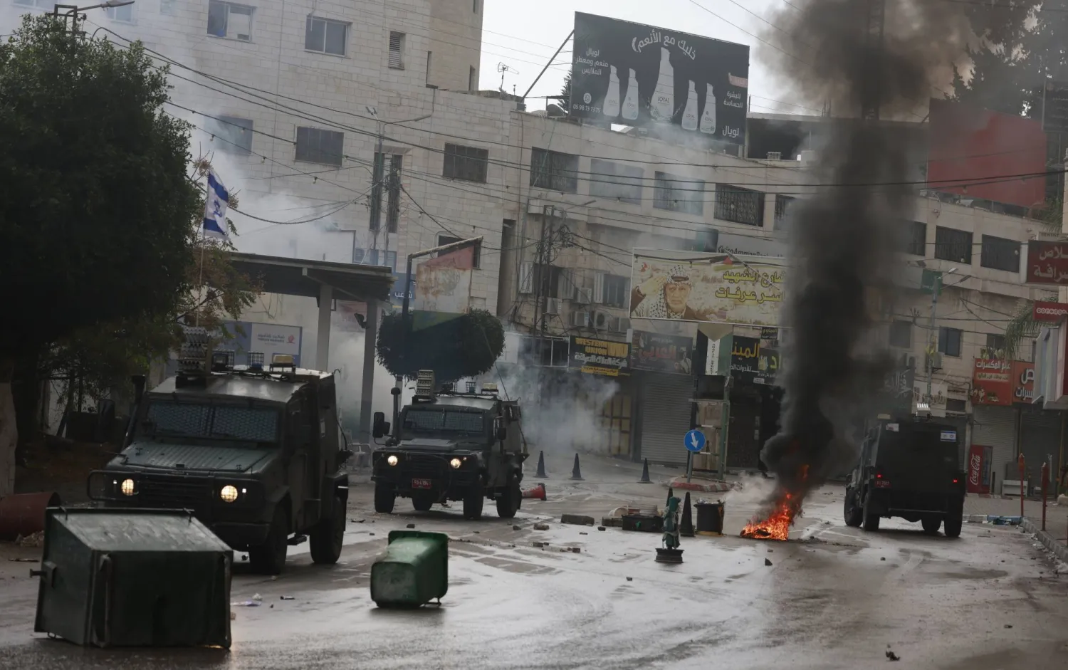 القوات الإسرائيلية تغلق الشارع الرئيسي خلال مواجهات بعد عملية في مخيم طولكرم للاجئين بالضفة الغربية (إ.ب.أ)