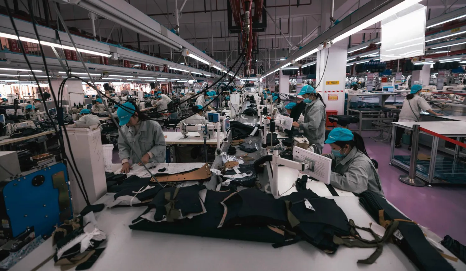 عمال في مصنع «هواليدا» للملابس في تشانغتشو بمقاطعة جيانغسو الصينية (إ.ب.أ)