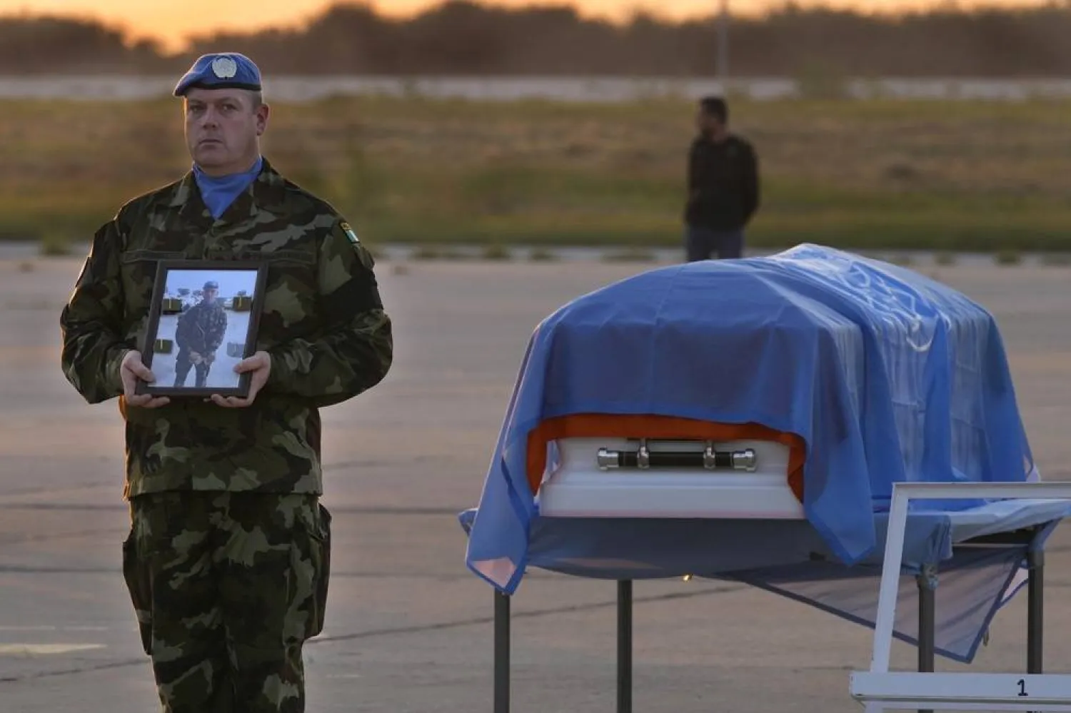 An Irish UN peacekeeper stands next to the coffin of his comrade Pvt. Seán Rooney, who was killed during a confrontation with residents near the southern town of Al-Aqbiya on Wednesday night, during a memorial service, at Beirut airport, Sunday, Dec. 18, 2022. (AP) 