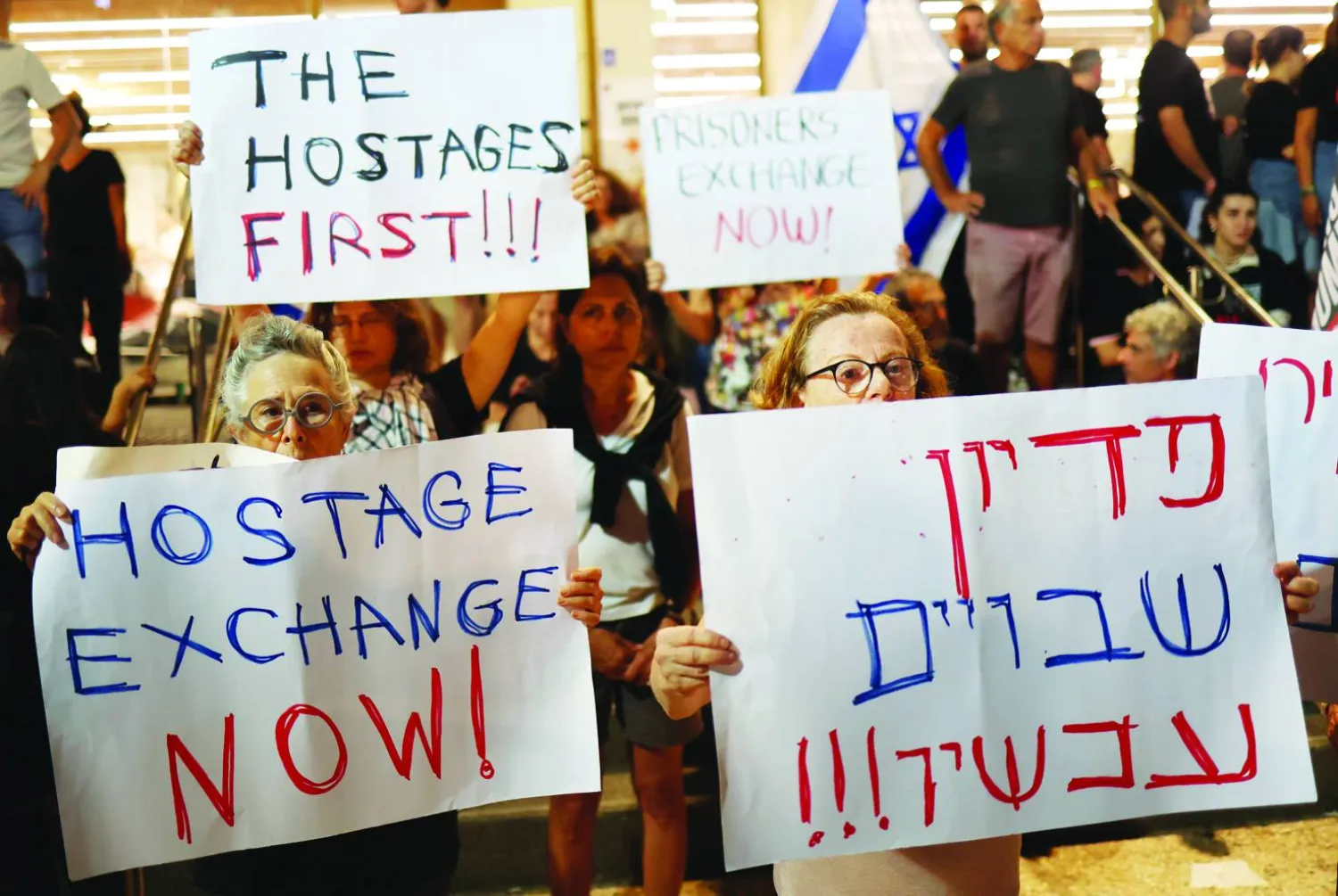 متظاهرون يحملون لافتات خلال مظاهرة تطالب بالإفراج عن الرهائن الذين تحتجزهم «حماس» في متحف الفن في تل أبيب 11 نوفمبر (إ.ب.أ)