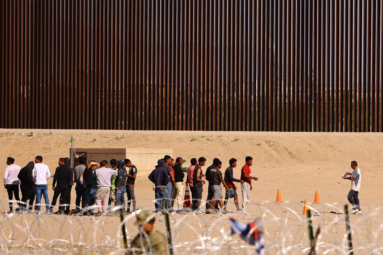 Migrants gather near the border wall after crossing the Rio Bravo river with the intention of turning themselves in to the US Border Patrol agents to request asylum, as seen from Ciudad Juarez, Mexico October 5, 2023. REUTERS/Jose Luis Gonzalez